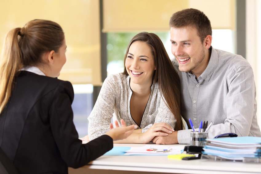 Junges Paar beim Beratungsgespräch mit einer Angestellten der Wohnungsgesellschaft